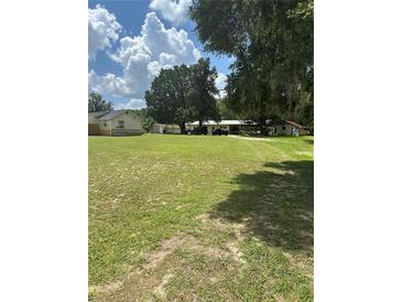Spacious front yard with two houses and mature trees at 7400 E Hwy 25, Belleview, FL 34420