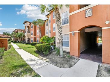 Exterior view of residential building with walkway and landscaping at 5530 Metrowest Blvd # 9-211, Orlando, FL 32811