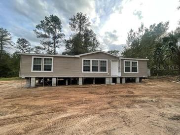 Single wide manufactured home on a dirt foundation at 18955 Se 107Th Pl, Ocklawaha, FL 32179