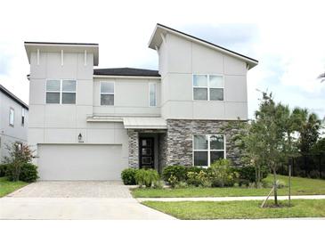Two-story modern home with stone accents and a landscaped front yard at 1864 Caribbean View Ter, Kissimmee, FL 34747
