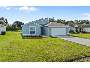 Newly built light blue house with a two-car garage and well-maintained lawn at 656 Koala Ct, Kissimmee, FL 34759