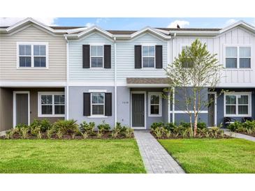 Two-story townhome with gray siding, landscaping, and walkway at 1436 Silver Lining Way, Apopka, FL 32703