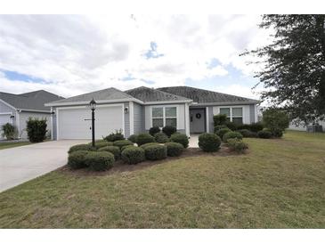 One-story house with gray siding and landscaped yard at 11188 Hess Way, Oxford, FL 34484