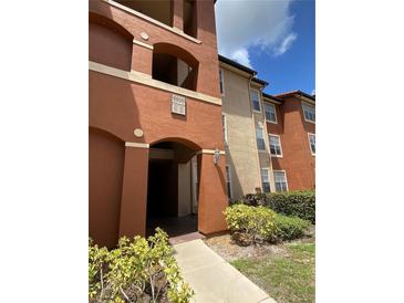 Condo building entrance with address numbers and landscaping at 5578 Metrowest Blvd # 107, Orlando, FL 32811