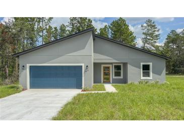 Modern house with a gray exterior, blue garage door and a small lawn at 5277 Sw 165Th Street Rd, Ocala, FL 34473