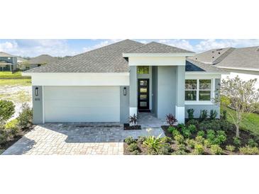 One-story home with gray exterior, two-car garage, and landscaped yard at 815 Liliana Dr, Deland, FL 32724