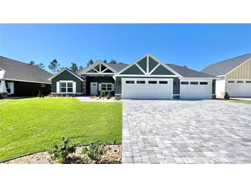 Beautiful two-story home with a three-car garage and well-manicured lawn at 6425 Sw 180Th Cir, Dunnellon, FL 34432