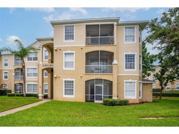 Three-story condominium building with balconies and lush landscaping at 8105 Coconut Palm Way # 203, Kissimmee, FL 34747