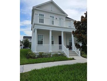 Two-story house with white columns and balcony at 7410 Barrier Cove Way, Kissimmee, FL 34747