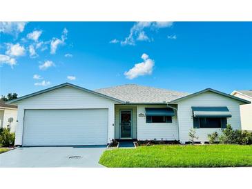 White single story home with a two car garage and landscaped lawn at 4901 Pleasant Hollow Trl, Lakeland, FL 33811