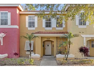 Two-story townhome with inviting front porch and landscaping at 1121 Park Ridge Cir, Kissimmee, FL 34746