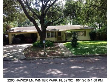 Ranch-style home with carport, mature trees, and well-maintained lawn at 2260 Hawick Ln, Winter Park, FL 32792