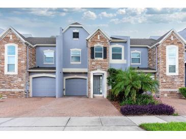 Stunning three-story townhome with stone accents and two-car garage at 2286 Chatham Place Dr, Orlando, FL 32824