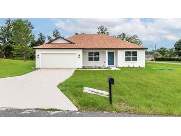 Charming one-story home with a two-car garage and well-maintained lawn at 11 Spruce Pass, Ocala, FL 34472