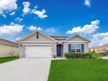 Single-story home with a two-car garage and neatly landscaped front yard at 1502 Jadewood Way, Kissimmee, FL 34744