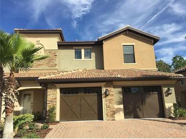 Two-story townhome with double garage and stone accents at 8975 Azalea Sands Ln, Davenport, FL 33896