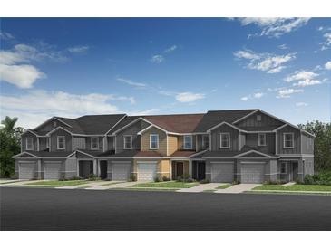 Three-unit townhouse building with attached garages and well maintained lawn at 426 Sequoia Dr, Lake Wales, FL 33859