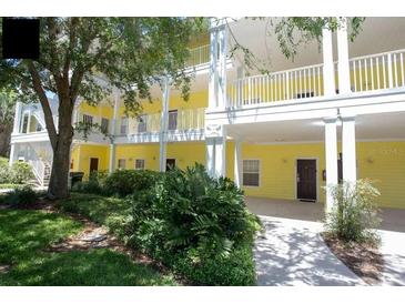 Yellow two-story building with walkway and landscaping at 703 Lucaya Loop # 1103, Davenport, FL 33897