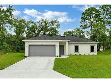 New construction home with gray garage door at 556 Marion Oaks Pass, Ocala, FL 34473