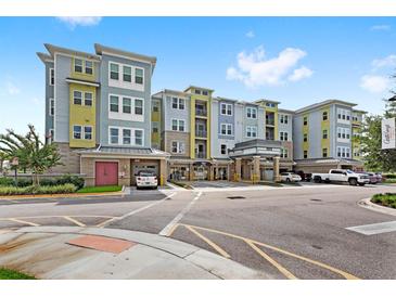 Modern apartment building with parking and landscaping at 7573 Laureate Blvd # 1301, Orlando, FL 32827