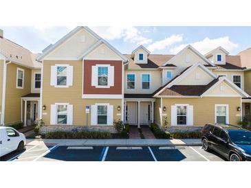 Tan and red three-story townhouses with white trim at 7574 Sunny Dreams Ln, Kissimmee, FL 34747