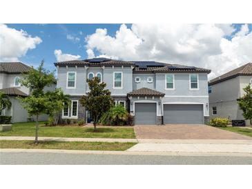 Two-story house with gray siding, solar panels, and two-car garage at 8324 Ludington Cir, Orlando, FL 32836