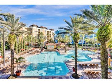 Resort-style pool with lounge chairs and palm trees at 12544 Floridays Resort Dr # 203-B, Orlando, FL 32821