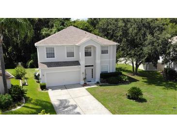 Two-story house with a light beige exterior, gray roof, and a two-car garage at 276 Tavestock Loop, Winter Springs, FL 32708