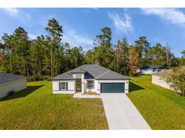 Single-story home with gray roof and attached garage, nestled in a wooded lot at 602 Marion Oaks Blvd, Ocala, FL 34473