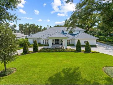 Stunning two-story home with a tile roof, lush landscaping, and a large driveway at 9648 Mccormick Pl, Windermere, FL 34786