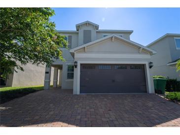 Two-story house with brown garage door and brick paver driveway at 7432 Marker Ave, Kissimmee, FL 34747