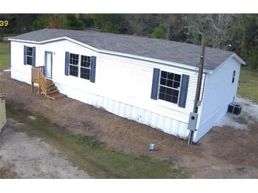 Newly constructed mobile home with gray roof and blue shutters at 2058 8Th St, Orlando, FL 32820