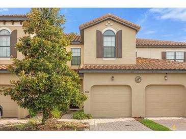 Townhouse exterior with two-car garage and lush landscaping at 8110 Roseville Rd, Davenport, FL 33896