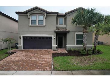 Two-story house with a two-car garage and a brick driveway at 8829 Corcovado Dr, Kissimmee, FL 34747