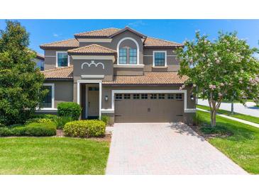 Two-story home with a modern facade, three-car garage and manicured lawn at 9101 El Caro Ln, Davenport, FL 33896