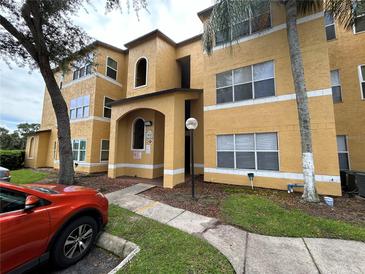 Three-story building with tan exterior and parking at 4642 Commander Dr # 933, Orlando, FL 32822