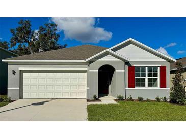 Charming single-story home with gray siding, white garage door, and red shutters at 5425 Hayloft Dr, Apopka, FL 32712