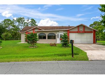 Single-story home with attached garage and manicured lawn at 636 Koala Ct, Poinciana, FL 34759