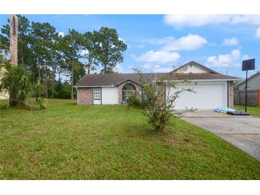 Brick house with a white garage door and a basketball hoop in the yard at 2921 Omaha Dr, Deltona, FL 32738