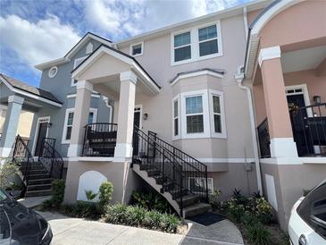 Townhouse with stairs and light pink exterior at 6624 Time Square Ave # 104, Orlando, FL 32835