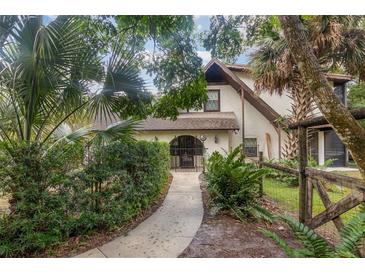 Front entry with a walkway, lush landscaping, and a rustic fence at 5006 Cub Lake Dr, Apopka, FL 32703