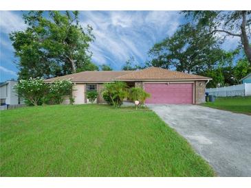 Brick ranch home with pink garage door at 5924 White Egret Ln, Orlando, FL 32810