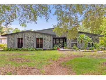 Ranch style home with stone facade, landscaping, and a spacious lawn at 1521 Oxford Rd, Maitland, FL 32751