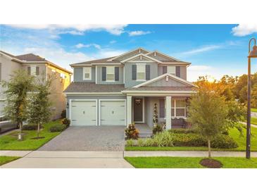 Two-story house with gray siding and two-car garage at 10472 Petrillo Way, Winter Garden, FL 34787