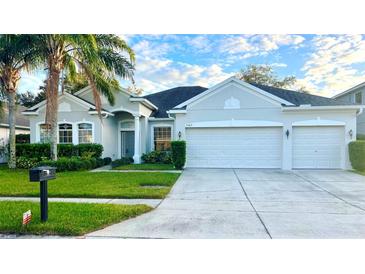 Two-story house with a three-car garage and landscaped yard at 7567 Brightwater Pl, Oviedo, FL 32765