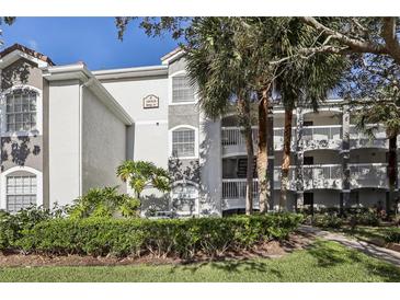 Exterior view of a condo building with lush landscaping and walkways at 13905 Fairway Island Dr # 1022, Orlando, FL 32837