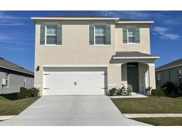 Two-story home with a double-car garage and neutral color palette at 2892 Waterlily Way, Poinciana, FL 34759