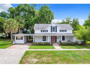 Charming two-story house with a covered porch and landscaped yard at 216 N Saint Clair Abrams Ave, Tavares, FL 32778