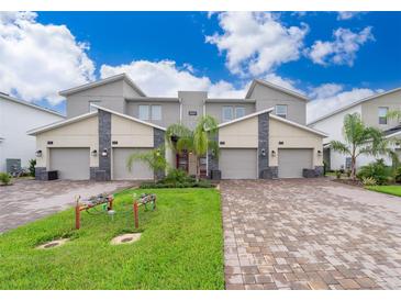 Modern three-unit townhome with driveway and landscaping at 8889 Cabot Cliffs Dr # 104, Davenport, FL 33896