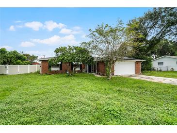 Brick house with a large front yard and a driveway at 1005 Crescent Pkwy, Deland, FL 32724